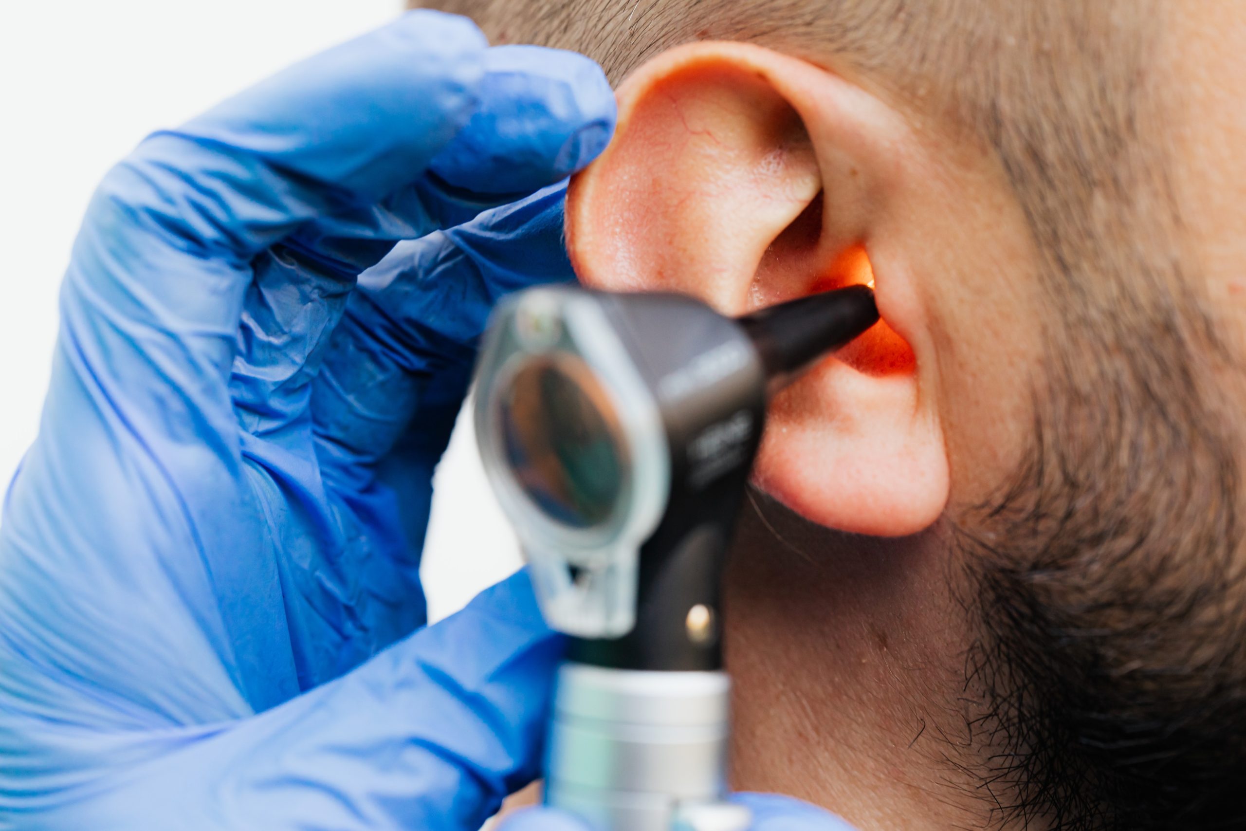 Hearing Checks - A gentleman having his ear checked with an Otoscope by an Audiologist.